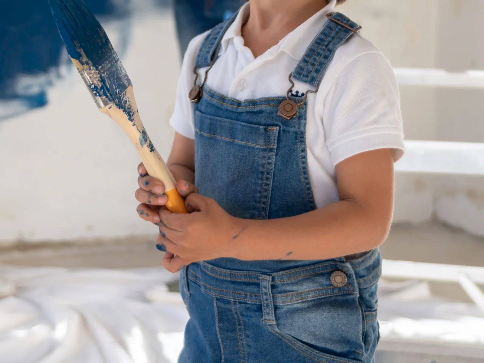 A boy holding a paint brush