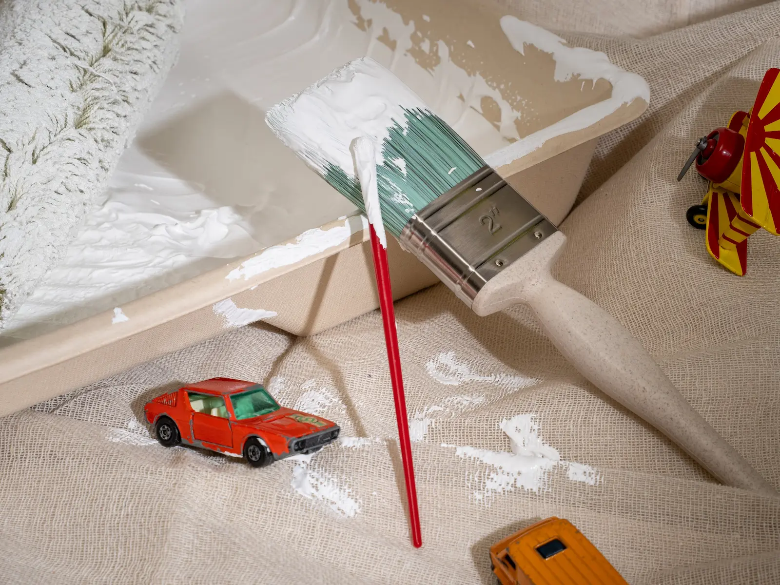 Heroes Shield anti-mould paint in a tray surrounded with toys