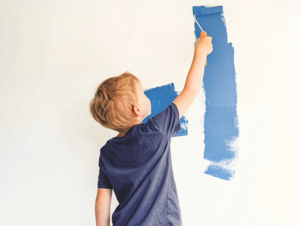 A boy painting a wall